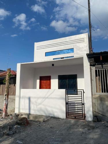una casa blanca con una puerta delante de ella en ANDRO'S LOFT near General Santos City Airport, en General Santos