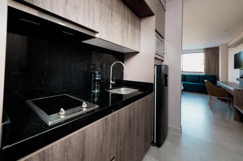 a kitchen with a sink and a counter top at Amari Living Suites in Barranquilla