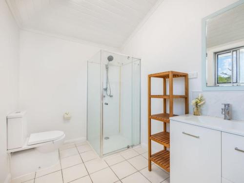 uma casa de banho com um chuveiro, um WC e um lavatório. em Family friendly cozy 4BR house at Annerley em Brisbane