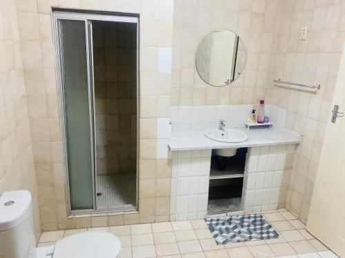 a bathroom with a shower and a sink and a toilet at Flamingo B&B in Richards Bay