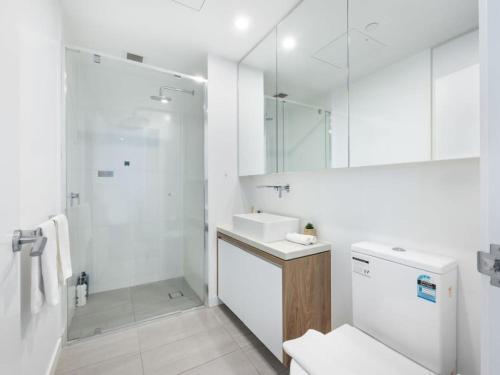 a white bathroom with a sink and a shower at Story Bridge and City View Skyhigh Luxe 2 bed Unit in Brisbane