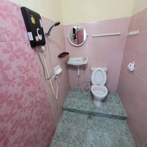 Baño de color rosa con aseo y lavamanos en Chamchuree Residence en Jomtien Beach