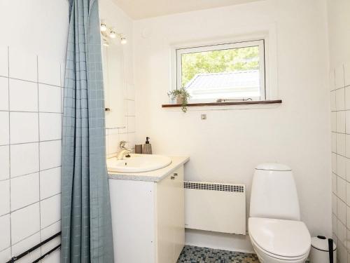 La salle de bains est pourvue de toilettes, d'un lavabo et d'une fenêtre. dans l'établissement Holiday home Læsø, à Læsø