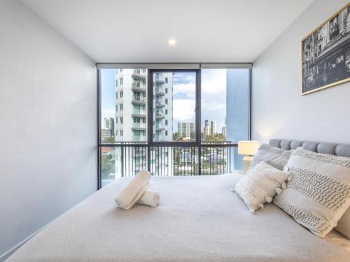 a bedroom with a bed with a large window at Riverside 2BR delicate apt in Gold Coast