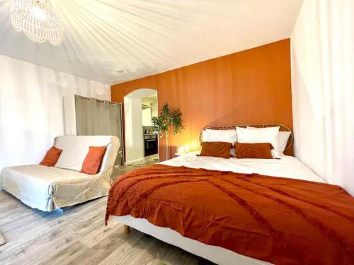 1 dormitorio con 1 cama grande y 1 silla en Grand Studio Chez Soi - Queen size bed - Terrasse, en Oyonnax