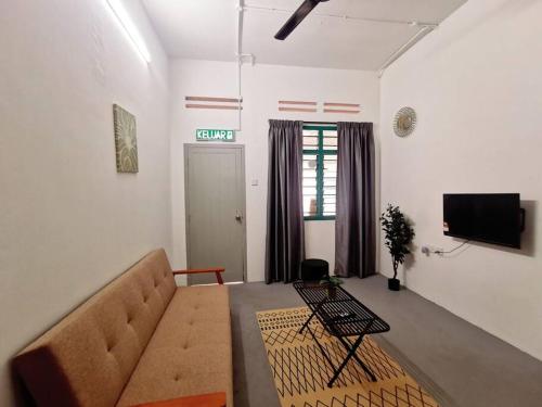 a living room with a couch and a flat screen tv at Ipoh town centre glamping home 13pax in Ipoh