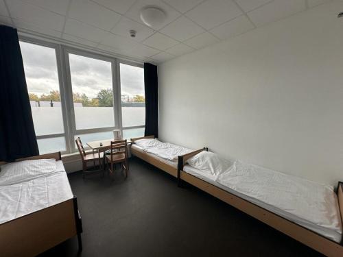 Arena Hostel & Monteurzimmer في هامبورغ: غرفة بسريرين وطاولة وكراسي