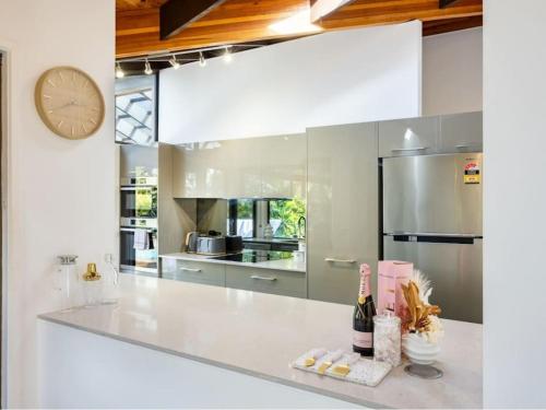 a large white kitchen with a clock on the wall at Hidden Bali style 5BR house in Robertson in Brisbane