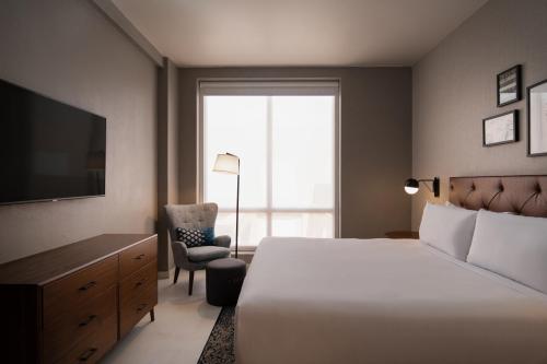 Un dormitorio con una cama, un televisor y una silla. en Four Points by Sheraton , en Punta Cana