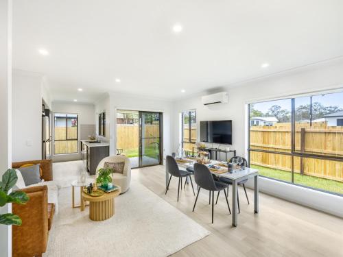 a living room with a table and chairs at Well decorated cozy 3BR home at Browns Plain in Browns Plains