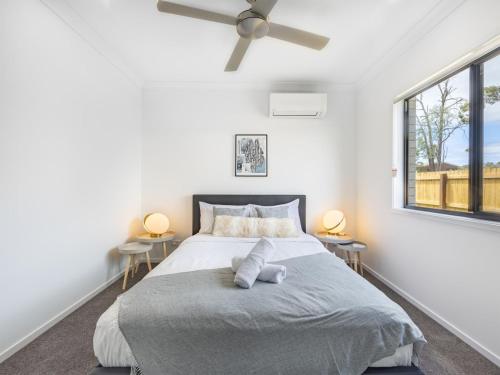 a bedroom with a large bed and two windows at Well decorated cozy 3BR home at Browns Plain in Browns Plains