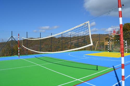 a tennis court with a net on top of it at Lola apartman Milmari & Residence Hill in Kopaonik