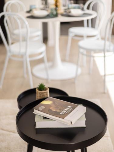 a black coffee table with books on it with chairs at Brand New 2BR well designed home at Brown Plains in Browns Plains