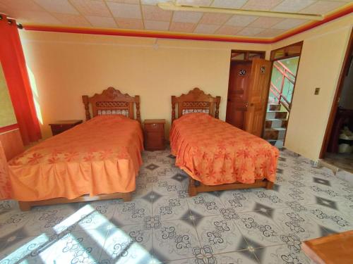 two beds sitting next to each other in a room at Hostal Puesta de Sol in Uyuni