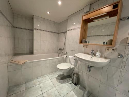 ein Badezimmer mit einem Waschbecken, einem WC und einer Badewanne in der Unterkunft Gasthof zum Rößle Lautrach in Lautrach