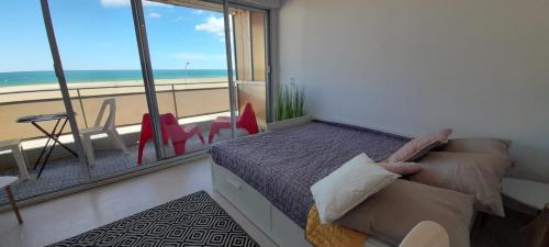 um quarto com uma cama e vista para a praia em Sur la Plage em Port-la-Nouvelle