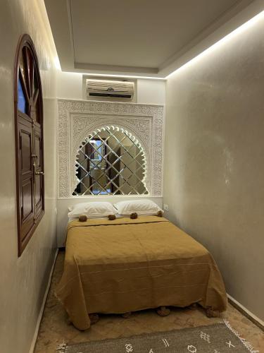 a bedroom with a bed in a room with a window at Riad Dar Yammi in Marrakesh