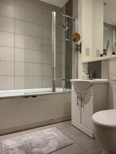 ein Bad mit einer Dusche, einem Waschbecken und einem WC in der Unterkunft studio flat in streatham in London