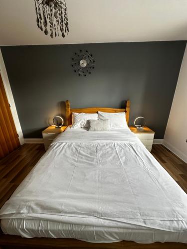 1 dormitorio con 1 cama blanca grande y 2 mesitas de noche en Two Bedroom Flat Town Centre Colchester, en Colchester