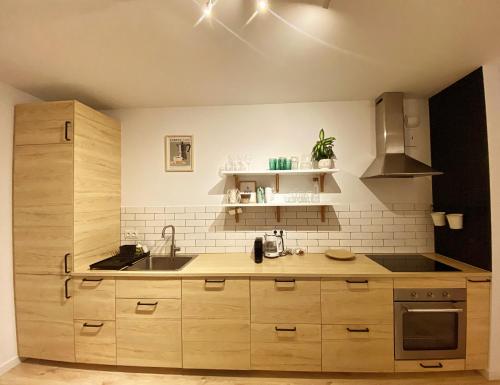 - une cuisine avec des placards en bois et un évier dans l'établissement Mint House Apartment, à Varsovie