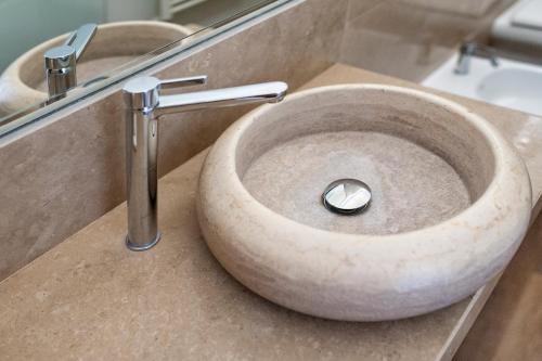 a stone sink in a bathroom with a mirror at Vittoria Luxury House in Lecce