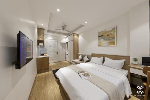 ein Hotelzimmer mit einem Bett und einem TV in der Unterkunft NB APARTMENT-LINH LANG in Hanoi