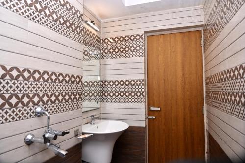 uma casa de banho com um lavatório e uma porta de madeira em Hotel Silver Land New Digha em Digha