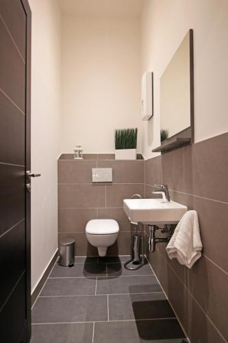 a bathroom with a white toilet and a sink at Apartment im Fun4you in Wiesloch