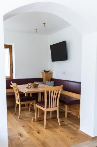 a dining room with a table and chairs and a tv at Appartement Monika in Neukirchen am Großvenediger