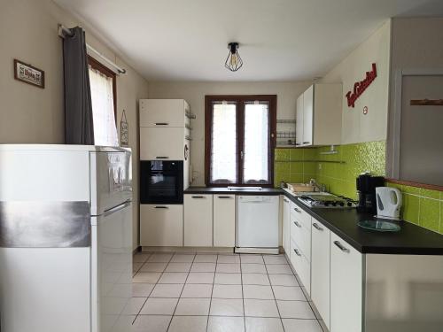 een keuken met witte apparatuur en groene muren bij Gîte 6-7 personnes pont de braye in Chastanier
