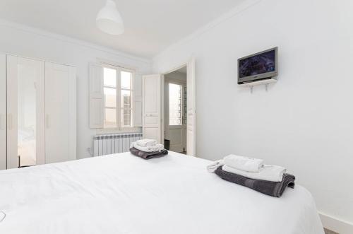 um quarto branco com uma cama grande e toalhas em YourHouse Es Pla Cycling House em Maria de la Salut