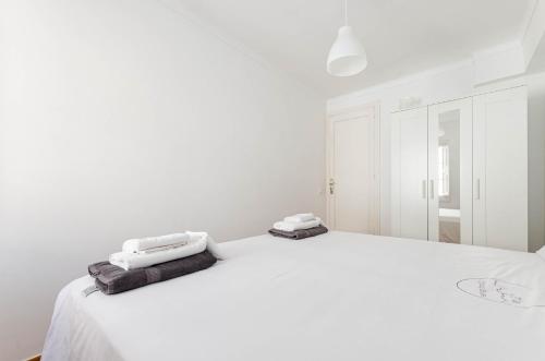 um quarto branco com uma grande cama branca com toalhas em YourHouse Es Pla Cycling House em Maria de la Salut