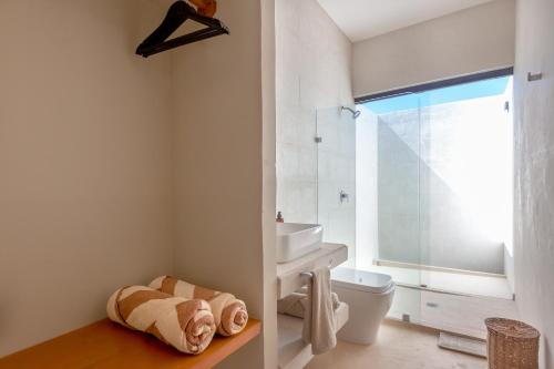 ein Bad mit einem Waschbecken, einem WC und einem Fenster in der Unterkunft Aparthotel Onda Maya - Adults Only in Holbox