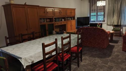 sala de estar con mesa con sillas y sofá en Hársfaapartman és vendégház en Gyula