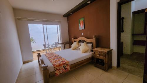 um quarto com uma cama, uma janela e uma mesa em Tuki Hostel & Lounge em Pereira
