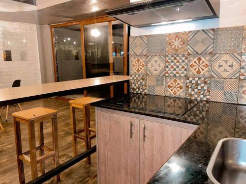 een keuken met een aanrecht en krukken in een kamer bij Departamento María in Baños