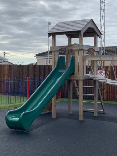 a playground with a green slide and a gazebo at MILLFIELDS AT INGOLDMELLS, Skegness in Tattershall