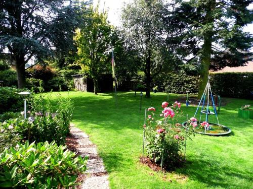 a garden with flowers and a swing in the grass at Pension C Blickfeld in Winsen Aller