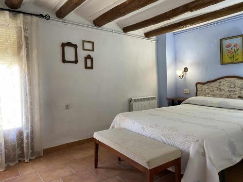 a bedroom with a white bed and a window at Casa Lola Beceite, terraza, barbacoa y chimenea in Beceite