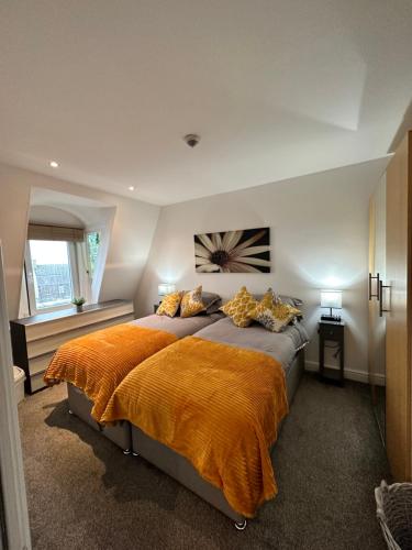 a bedroom with a large bed with an orange blanket at The Lookout, Bridlington in Bridlington