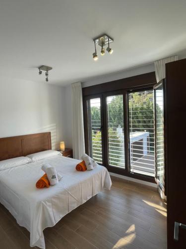 een slaapkamer met 2 bedden en een groot raam bij LA MESA in Félix