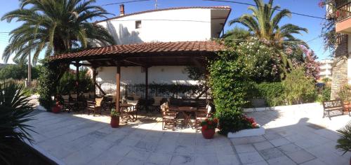 a patio with a gazebo and chairs and plants at Hotel Markos in Ierissos