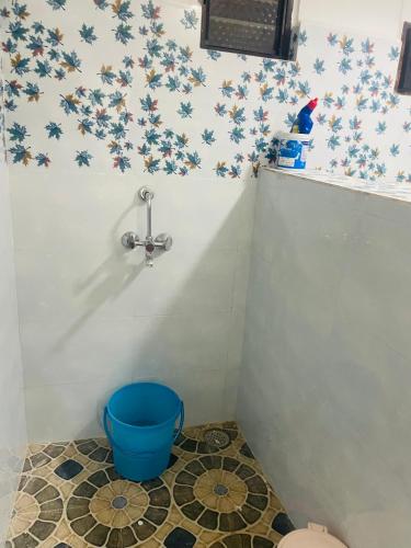 a bathroom with a blue bucket in the corner at Plefton Guest House in Agonda