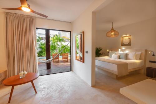 1 dormitorio con 1 cama y puerta corredera de cristal en Aparthotel Onda Maya - Adults Only, en Isla Holbox