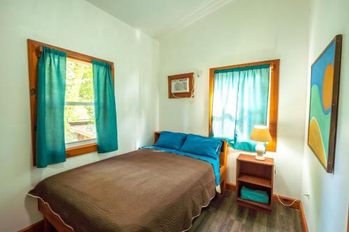 a bedroom with a bed and two windows at PirateArts Experience Resort in Bocas Town