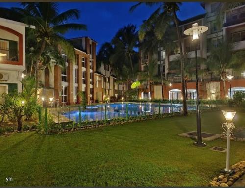 uma piscina no meio de um parque à noite em Luxurious Spacious 2 BHK With Pool Wi-Fi Cooking Gas Gym em Calangute