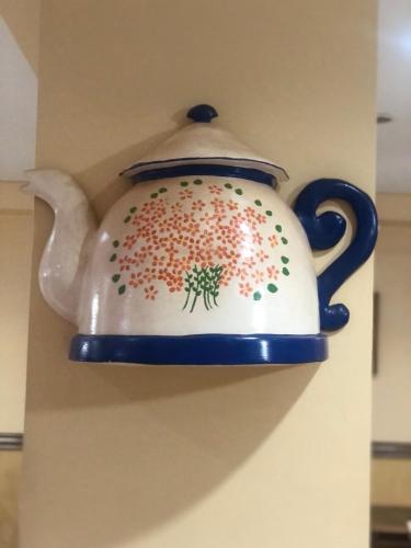 a tea pot hanging on a wall at Hotel Villa de Minas in Monte Sião