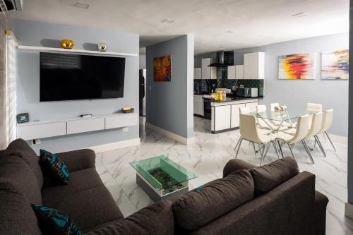 a living room with a couch and a tv and a table at Casas acogedoras en Bahia Azul in Cancún