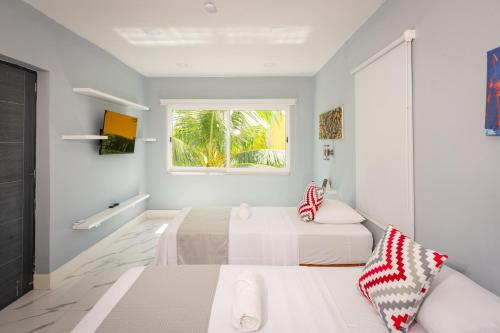 two beds in a white room with a window at Casas acogedoras en Bahia Azul in Cancún