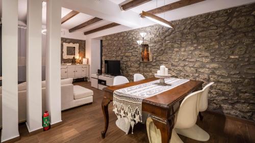 een eetkamer met een tafel en stoelen en een woonkamer bij Archhouse in Kalabaka